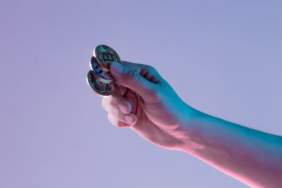 male-hand-with-golden-bitcoin-blue-background